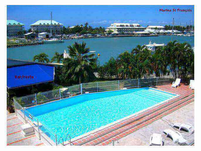 Location Appartement & Villa en Guadeloupe - piscine de la résidence avec en arrière plan la Marina