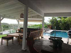 location Maison Villa Guadeloupe - Côté terrasse couverte de 50m2 avec carrelage anti-dérapant vue sur la piscine et la mer