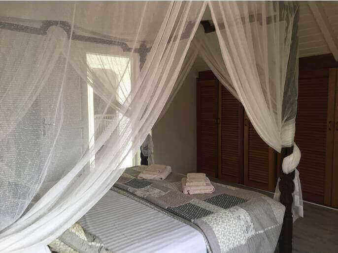 Location Maison & Villa en Guadeloupe - Suite (chambre avec salle de douche et WC indépendant)  climatisée à l'étage droite avec lit de 180 avec placard