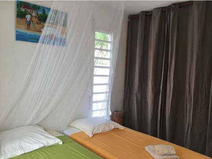 Location VillaMaison en Guadeloupe - Chambre climatisée RDC gauche avec 2 lits de 90 (pouvant être rapprochés) avec placard